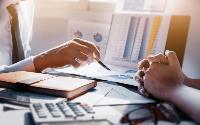 Obtenez des aides financières pour votre projet de rénovation énergétique © Adobe Stock Deux personnes à un bureau évaluant les financements possibles © Adobe Stock